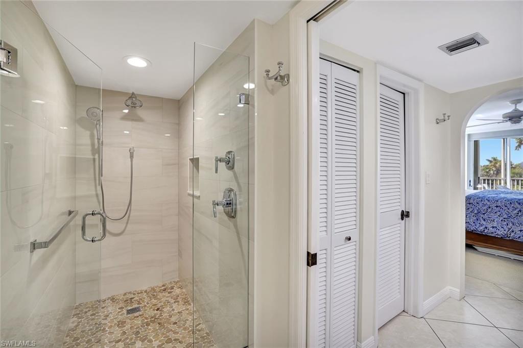 6573 Marissa Loop, Unit 302 Naples, FL 34108 - Photo 12 of 23 Full bathroom featuring a closet, connected bathroom, a stall shower, tile patterned floors, and a ceiling fan