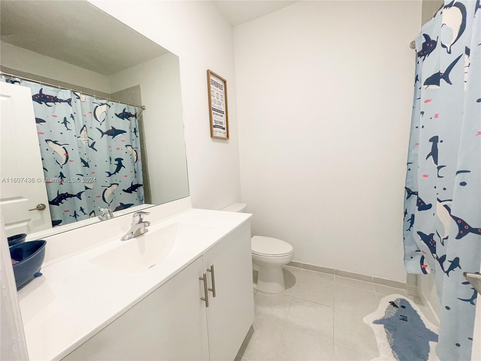 13414 Southwest 286th Street, Unit 13414 Homestead, FL 33033 - Photo 28 of 34 a bathroom with a sink a toilet and shower curtain