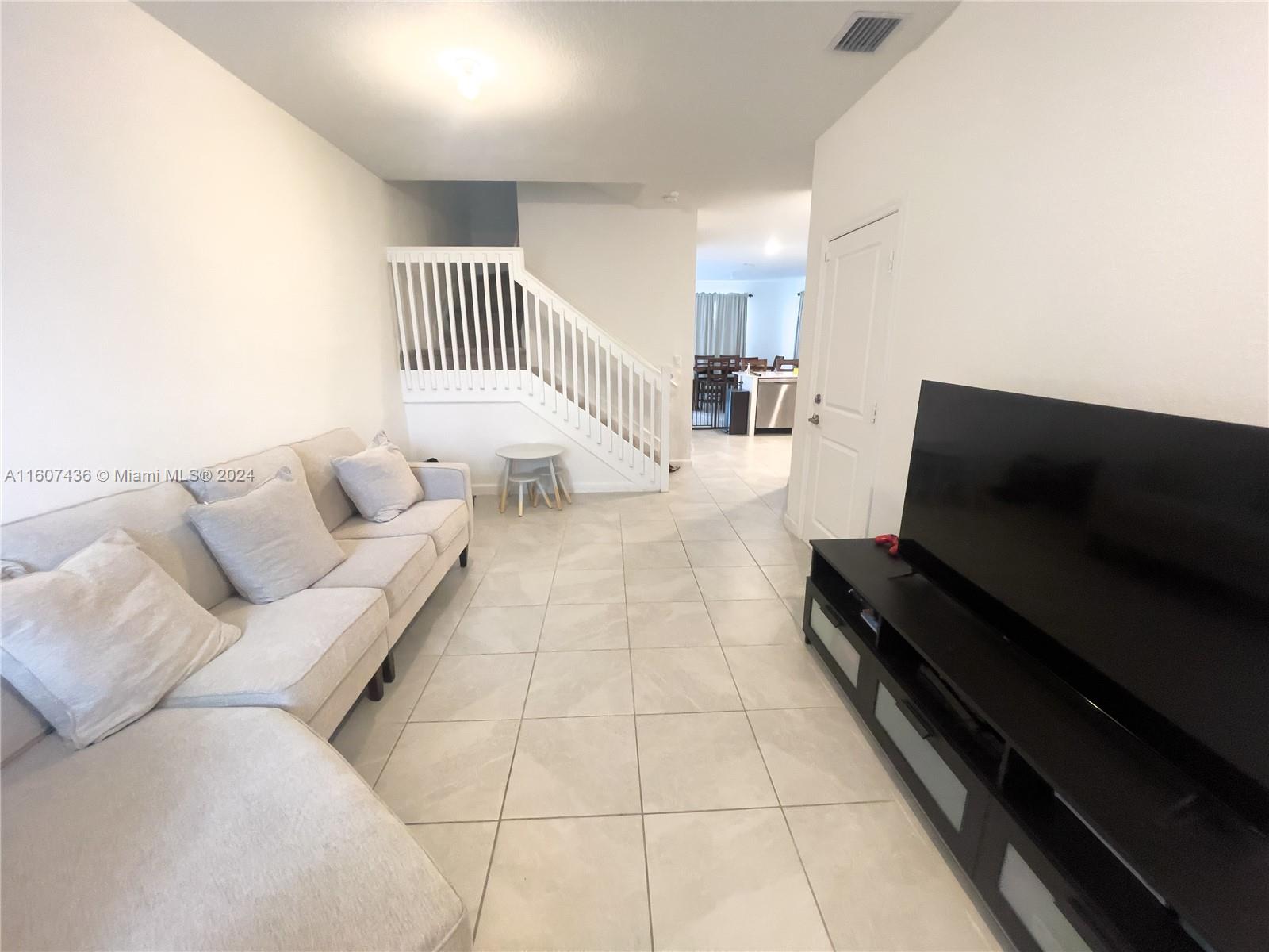 13414 Southwest 286th Street, Unit 13414 Homestead, FL 33033 - Photo 3 of 34 a living room with furniture and a flat screen tv