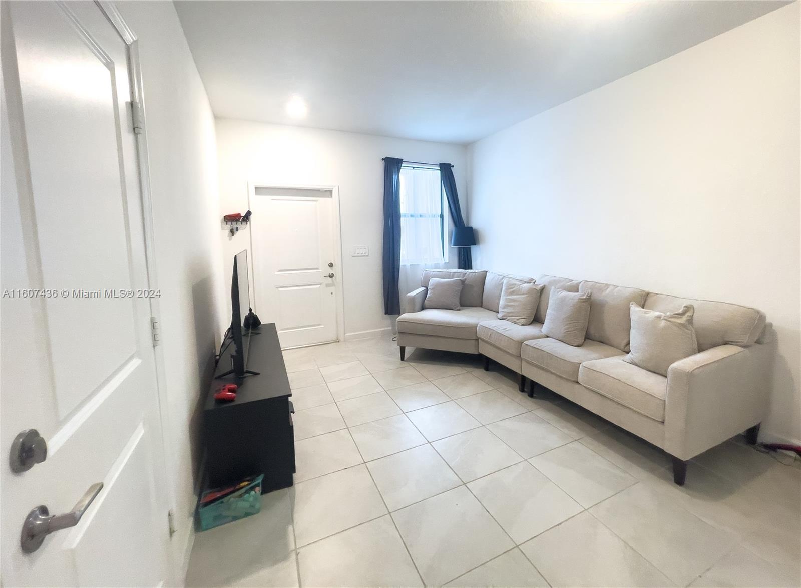 13414 Southwest 286th Street, Unit 13414 Homestead, FL 33033 - Photo 4 of 34 a living room with furniture and a floor to ceiling window