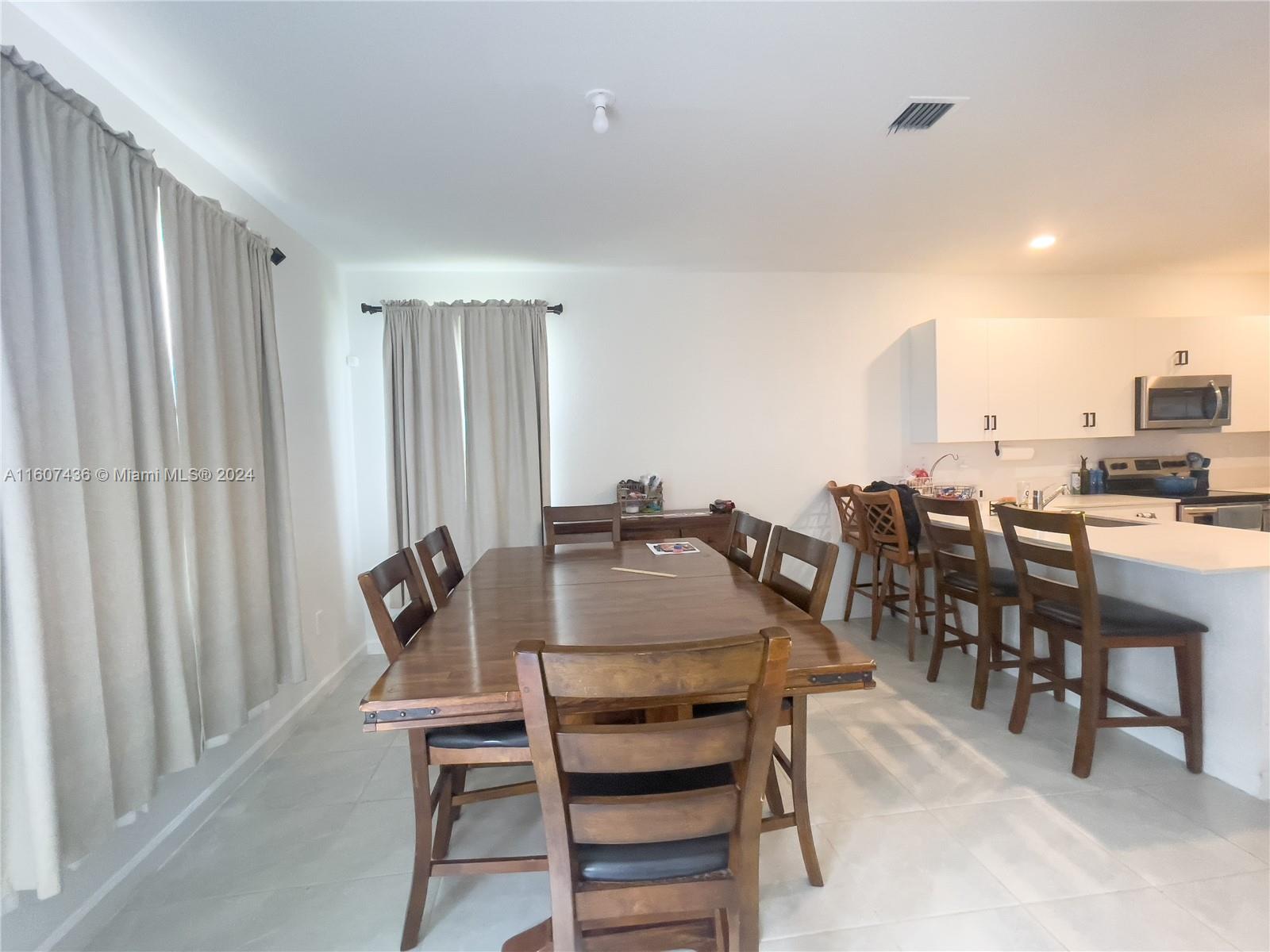 13414 Southwest 286th Street, Unit 13414 Homestead, FL 33033 - Photo 6 of 34 a view of a dining room with furniture and chandelier