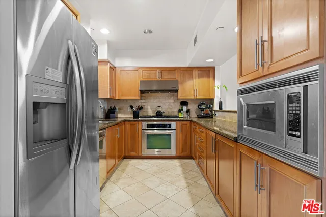 a kitchen with stainless steel appliances granite countertop a sink and a stove