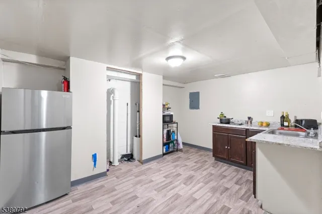 a kitchen with stainless steel appliances a refrigerator a sink dishwasher and a refrigerator with wooden floor