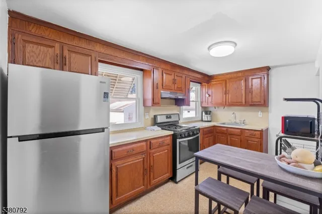 a kitchen with stainless steel appliances granite countertop a refrigerator stove top oven a sink and dishwasher