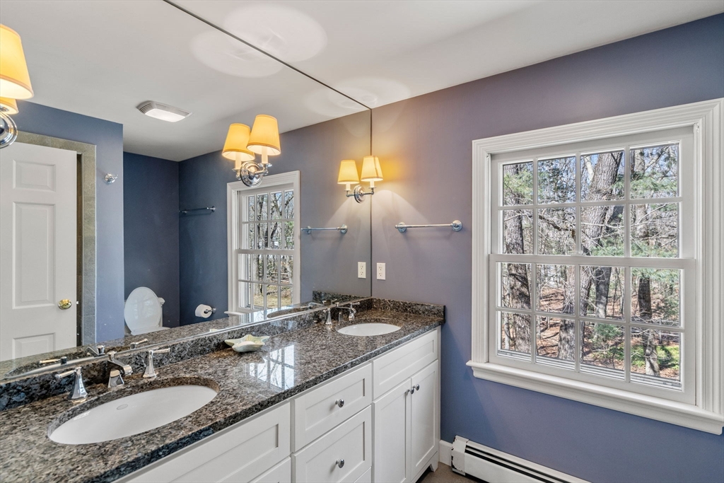 3 Goose Pond Road Lincoln, MA 01773 - Photo 28 of 37 a bathroom with a granite countertop sink a toilet a mirror and a window