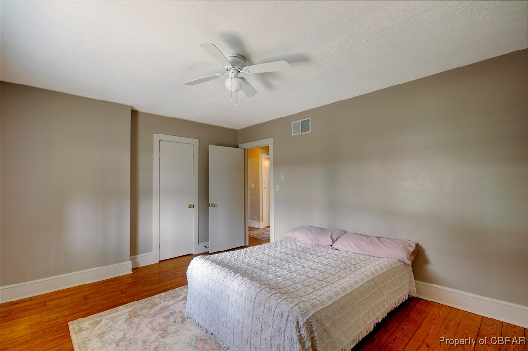 10371 Buckley Hall Road Mathews, VA 23109 - Photo 15 of 28 Bedroom with a ceiling fan, wood finished floors, baseboards, and visible vents