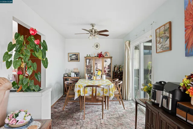 a view of a dining room with furniture a chandelier and a rug