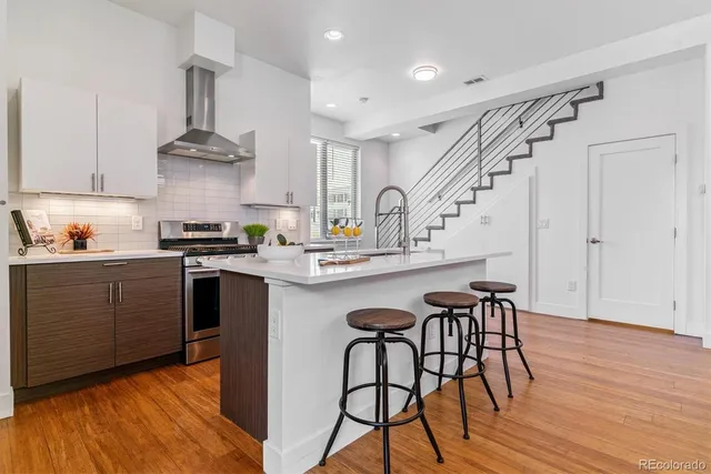 a kitchen with stainless steel appliances a dining table chairs stove and cabinets