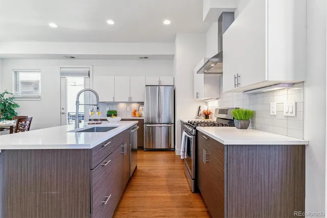 a kitchen with granite countertop a sink stove and refrigerator