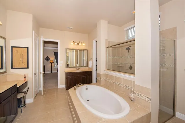 a spacious bathroom with a bathtub shower sink and mirror
