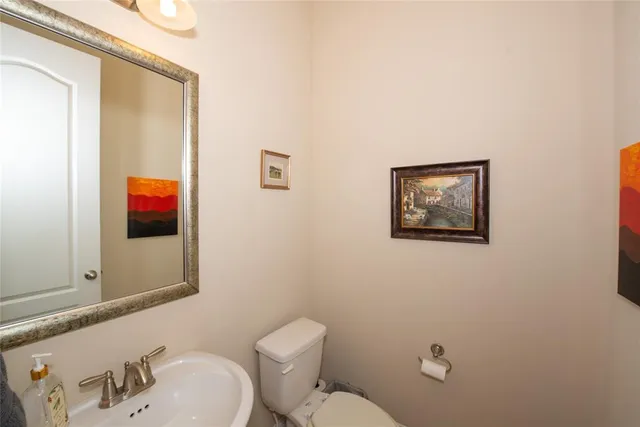 a bathroom with a toilet a sink and mirror