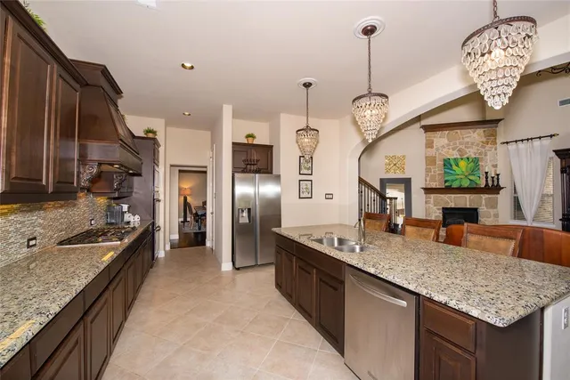 a kitchen with granite countertop a sink a counter top space appliances and cabinets
