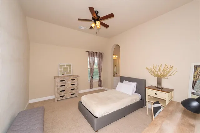 a bedroom with a bed a chandelier and a dresser