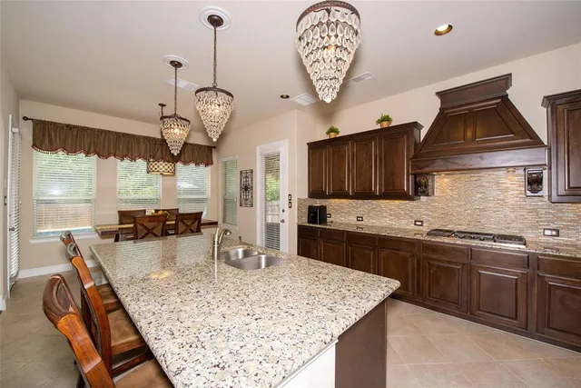 a kitchen with stainless steel appliances granite countertop a stove oven a sink dishwasher and a wooden cabinets