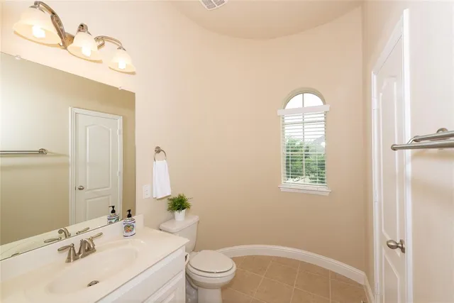 a bathroom with a sink vanity mirror and toilet