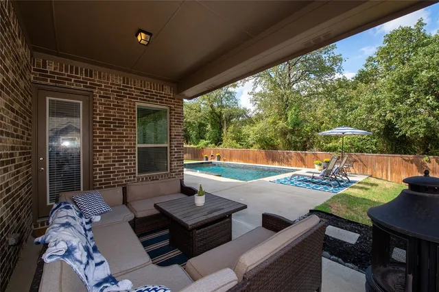 a view of a patio with a dining table and chairs with wooden floor