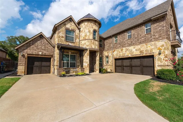 a front view of a house with yard and parking