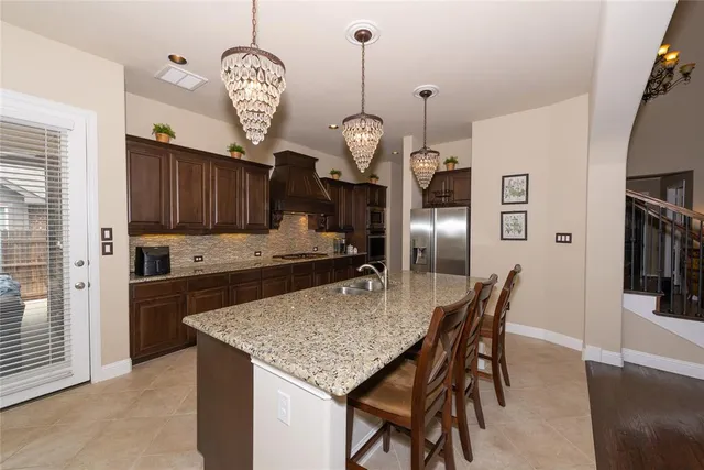 a kitchen with granite countertop stainless steel appliances a island dining table and chairs