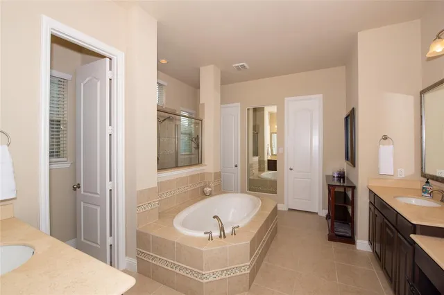 a bathroom with a tub sink shower and mirror