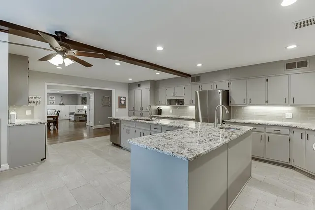 a kitchen with stainless steel appliances granite countertop a sink counter space cabinets and a large window