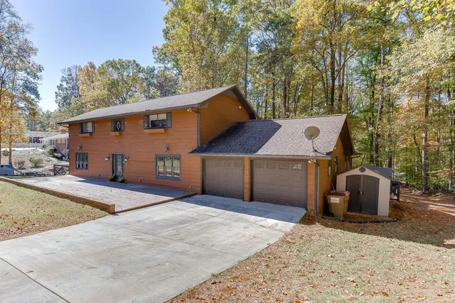 a view of a lake next to a road with large trees