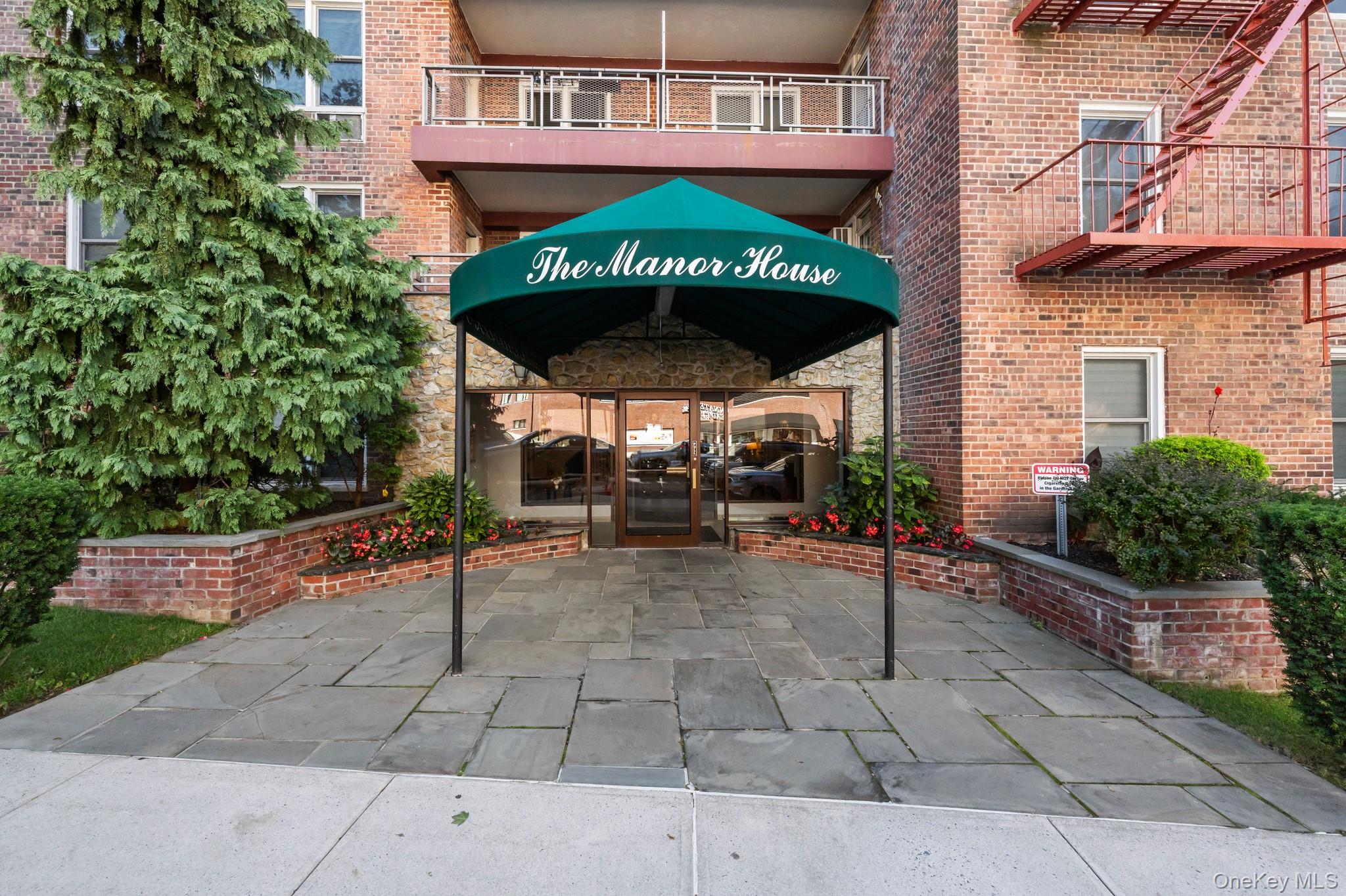 a view of a brick building with a bench under an umbrella