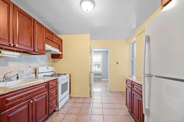 a kitchen with a sink refrigerator and cabinets