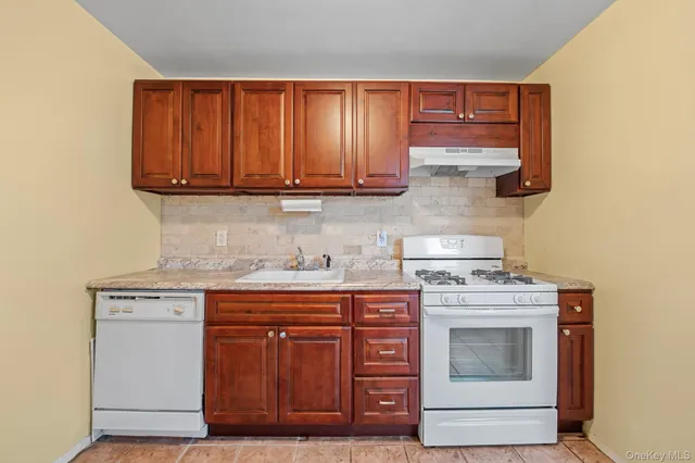 a kitchen with stainless steel appliances granite countertop wooden cabinets and a stove top oven