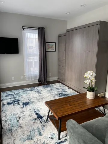a wooden floor with table and chairs in room