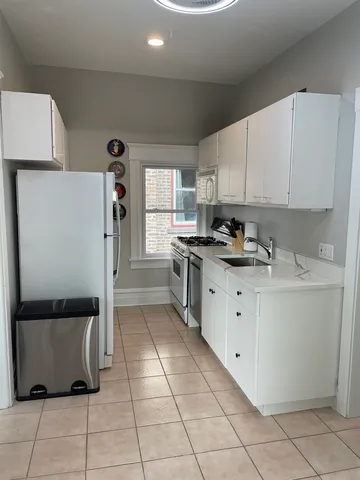 a kitchen with cabinets and a refrigerator