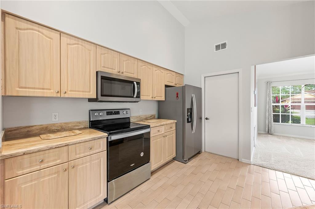 511 Ibis Way Naples, FL 34110 - Photo 11 of 46 a kitchen with a stove microwave and refrigerator