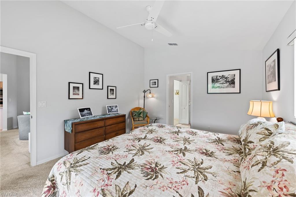 511 Ibis Way Naples, FL 34110 - Photo 21 of 46 a bedroom with a bed and a chandelier