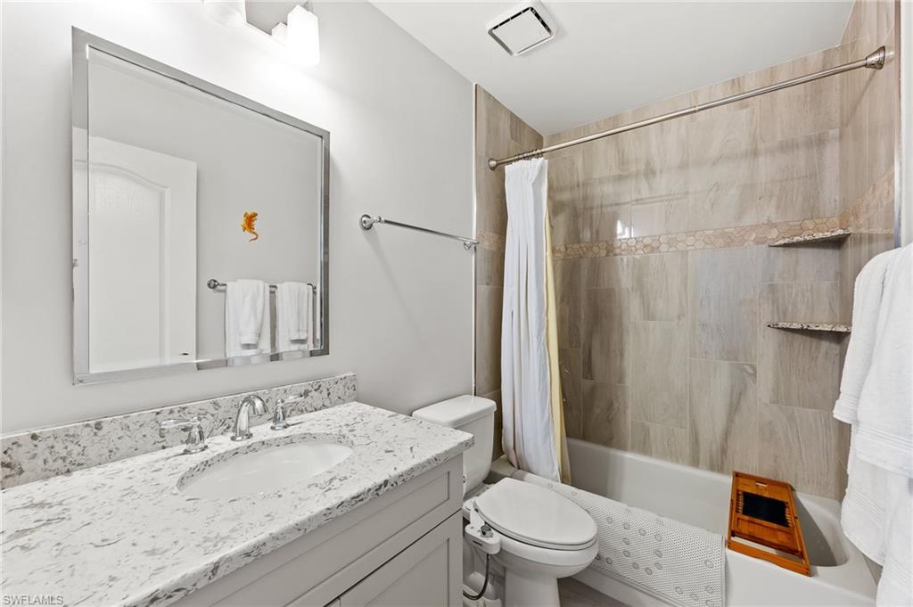 511 Ibis Way Naples, FL 34110 - Photo 28 of 46 a bathroom with a granite countertop sink toilet and shower