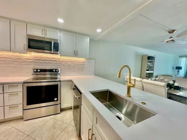 a kitchen with sink a microwave and stove