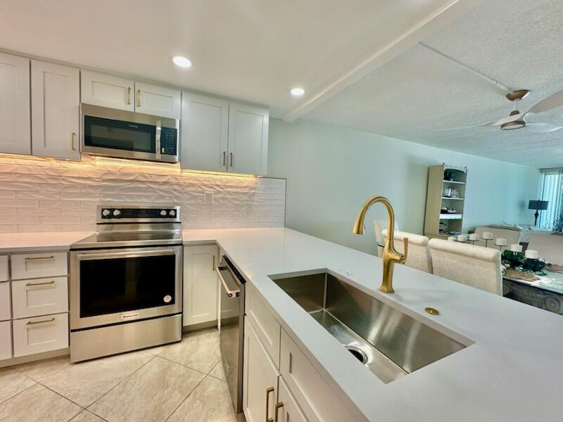 381 Santa Rosa Boulevard, Unit 709 Fort Walton Beach, FL 32548 - Photo 7 of 20 a kitchen with sink a microwave and stove