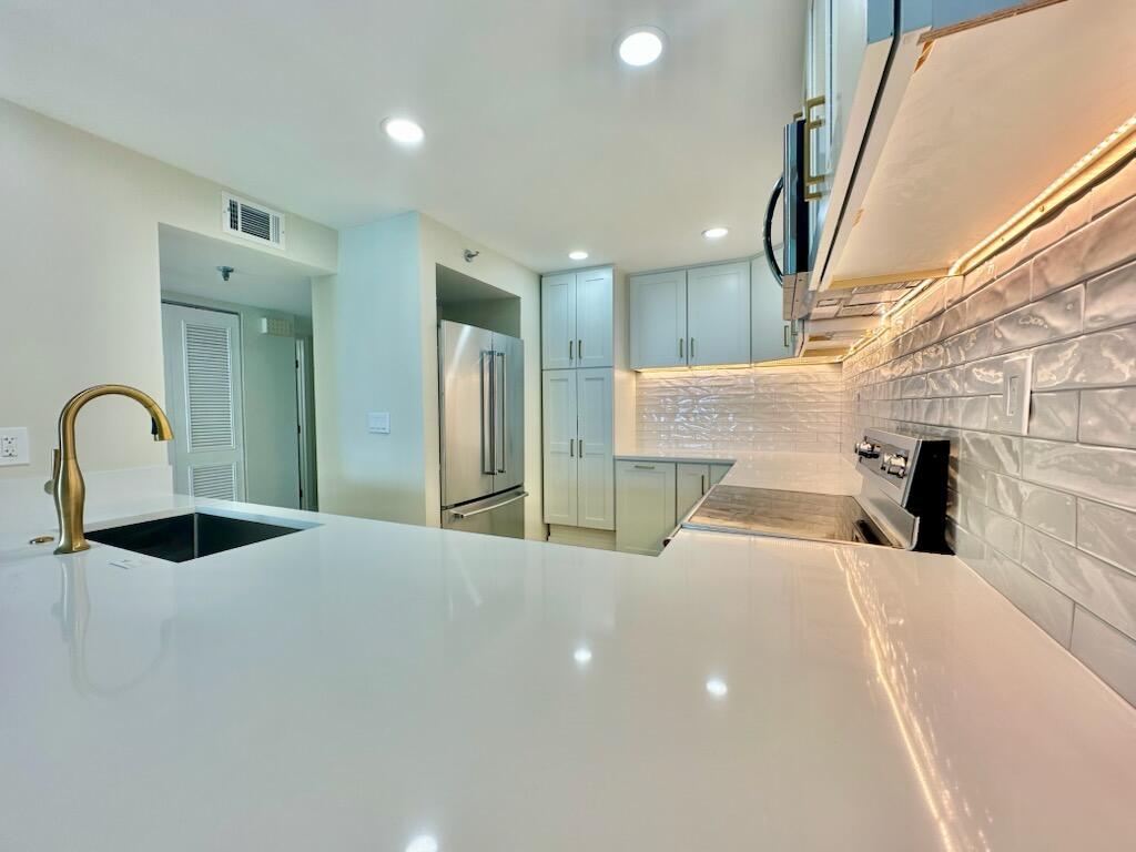 381 Santa Rosa Boulevard, Unit 709 Fort Walton Beach, FL 32548 - Photo 9 of 20 a large white kitchen with a sink and a large mirror