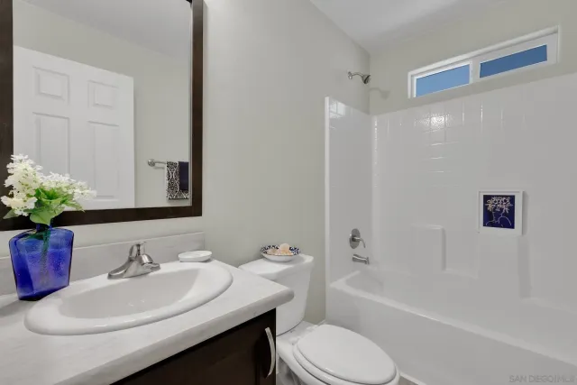 a bathroom with a granite countertop sink a toilet and shower