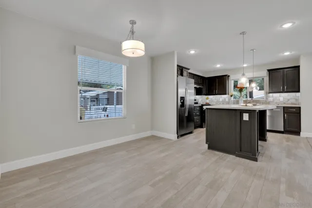 a open kitchen with kitchen island a sink stainless steel appliances and cabinets