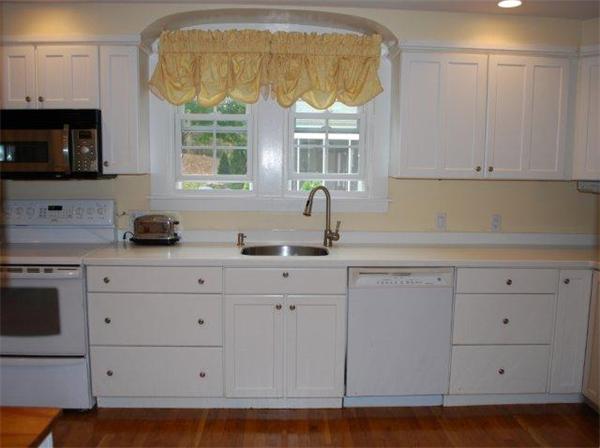 8 Thornton Road Waltham, MA 02453 - Photo 7 of 17 a kitchen with stainless steel appliances granite countertop a sink a stove and a microwave