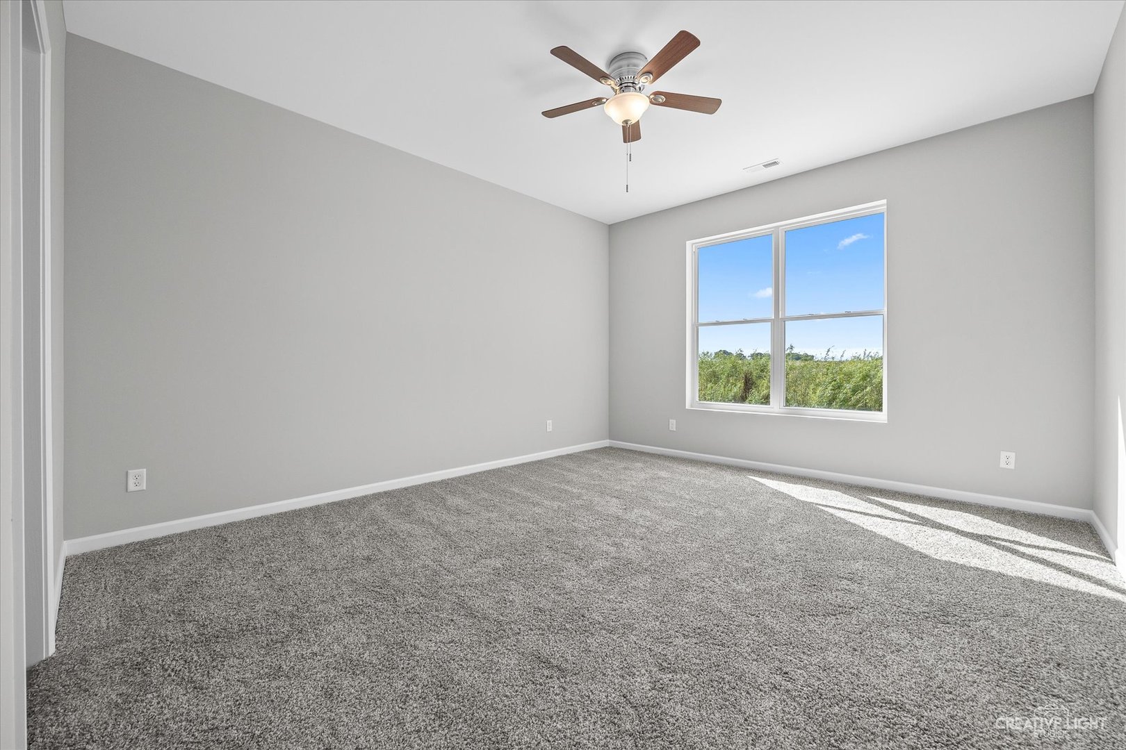 467 Preston Street Cortland, IL 60112 - Photo 11 of 17 an empty room with a window and a fan