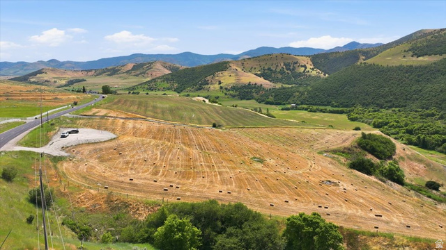 4250 East Cub River Road Preston, ID 83263 - Photo 12 of 18 Expansive agricultural landscape featuring a harvested field with hay bales, surrounded by green hills and distant mountains