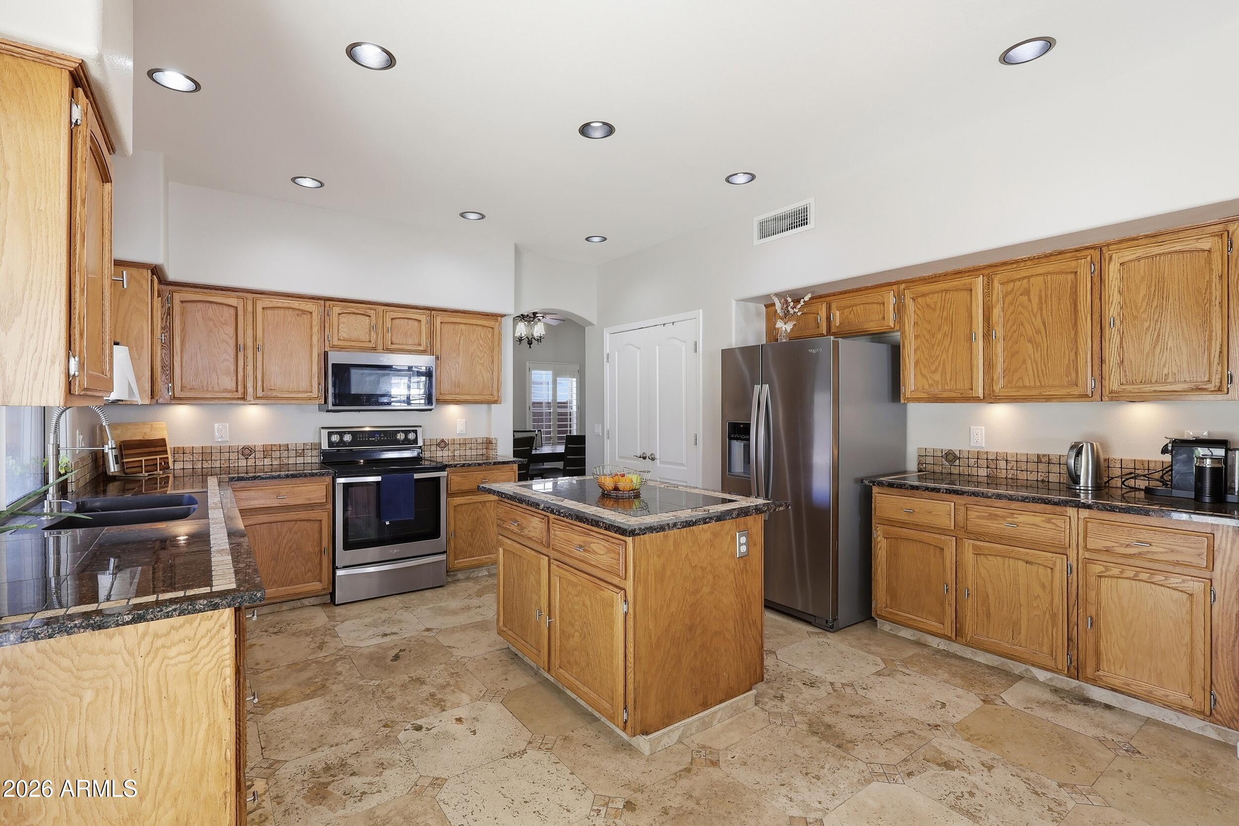 14025 South 44th Street Phoenix, AZ 85044 - Photo 11 of 52 a kitchen with stainless steel appliances granite countertop a stove top oven a refrigerator a sink and dishwasher