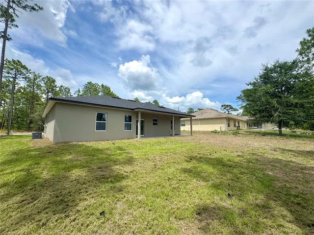 a view of backyard of house with green space