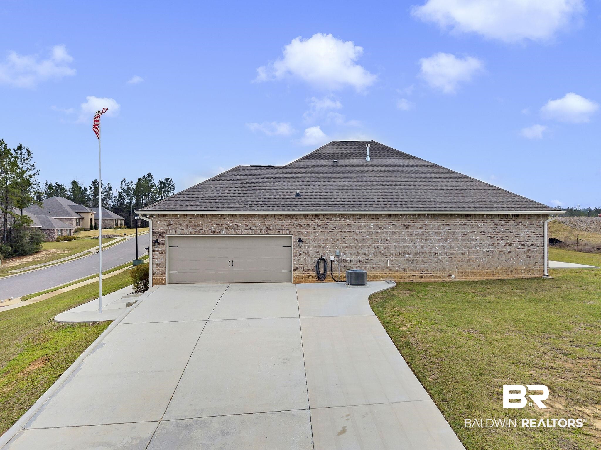 11247 Thistledown Loop Spanish Fort, AL 36527 - Photo 49 of 72 View of home's exterior featuring brick siding, a yard, roof with shingles, a garage, and driveway