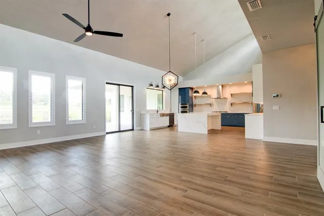 a view of empty room with wooden floor and windows