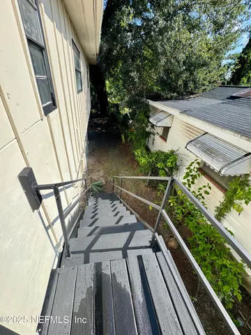 a view of a house with a yard and potted plants