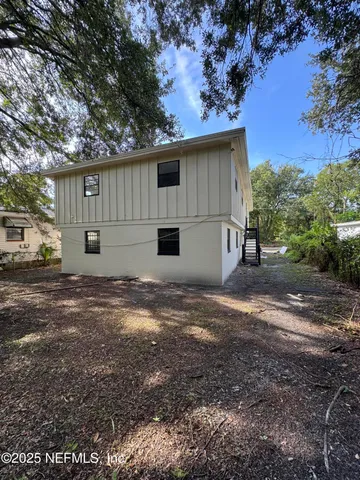 a view of a house with backyard and sitting area
