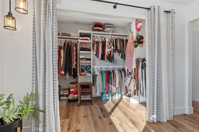 a view of walk in closet with clothes and shoes