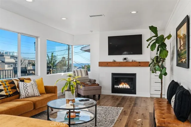 a living room with furniture a flat screen tv and a fireplace