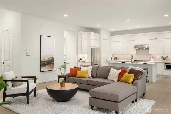 a living room with furniture and a view of kitchen